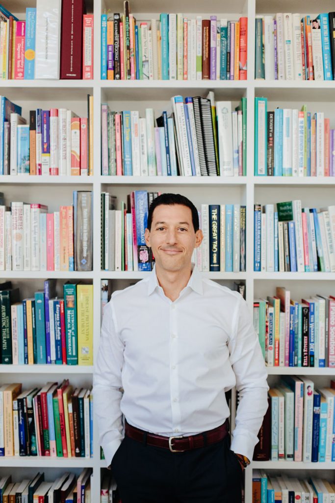 Dr. Cabral Standing at his book shelf